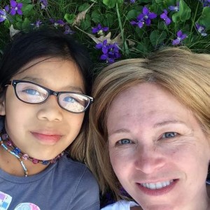 my daughter and I lying in the yard amongst the violets